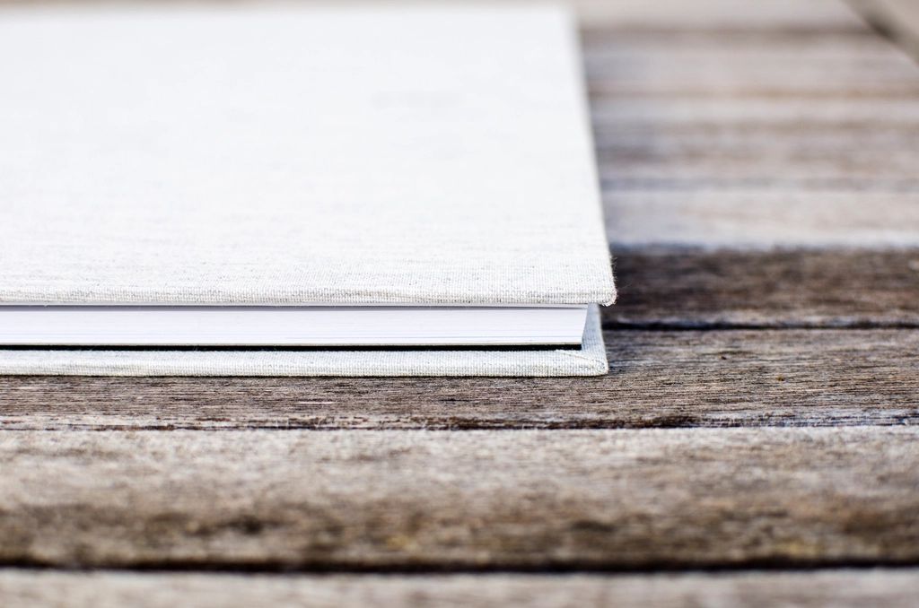Minimalist cream hardcover guest welcome book on a wooden table